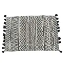 Location Tapis tissé beige avec motifs géométriques noirs et pompons